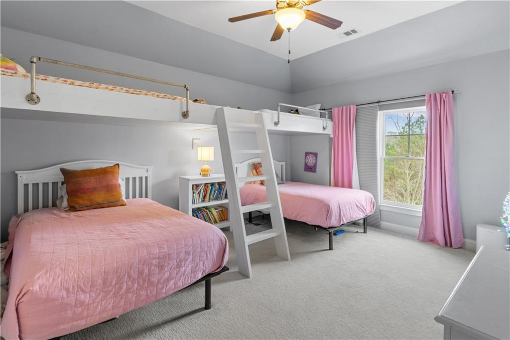 1625 Hamiota Ridge Alpharetta, GA 30004 - Photo 54 of 86 a bedroom with a bed and a chandelier