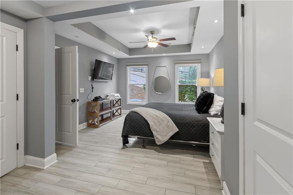 1625 Hamiota Ridge Alpharetta, GA 30004 - Photo 61 of 86 a spacious bedroom with a bed couch chandelier and a window