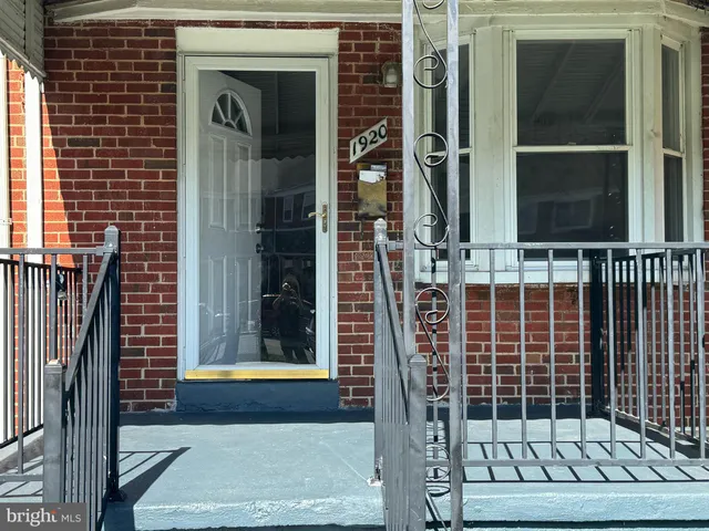 an empty room with wooden floor and a refrigerator