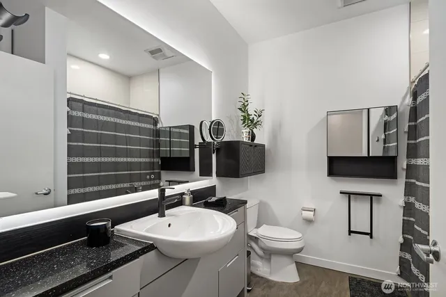 a bathroom with a toilet a sink and mirror