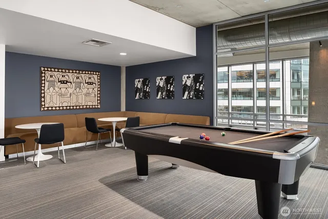 a room with furniture pool table and windows