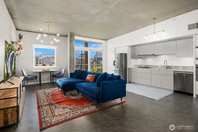a living room with furniture kitchen view and a chandelier