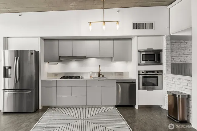 a kitchen with stainless steel appliances a stove a sink and a refrigerator