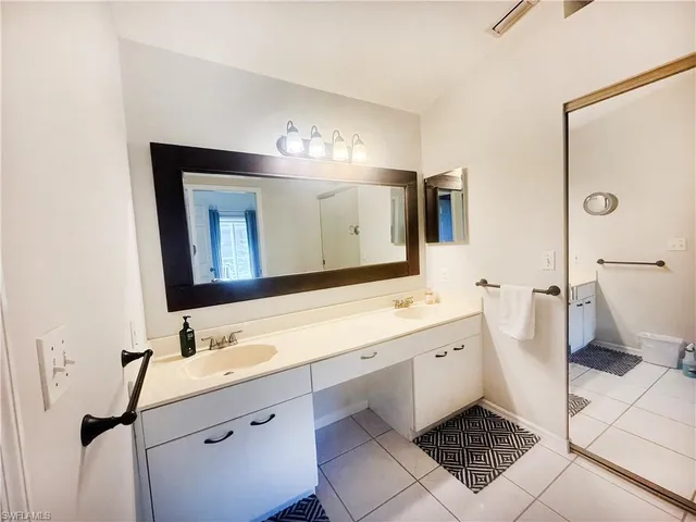 a bathroom with a double vanity sink mirror double and toilet