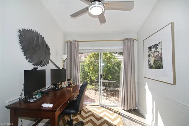 a view of a workspace with furniture and a window