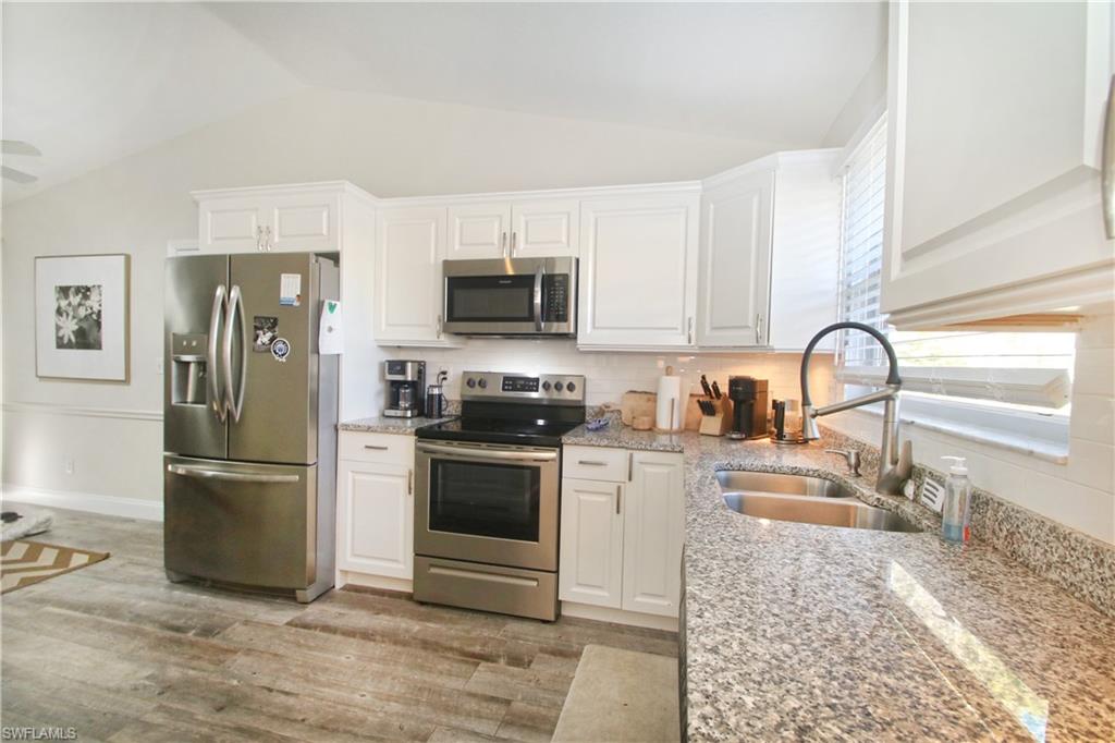 370 Emerald Bay Circle, Unit N8 Naples, FL 34110 - Photo 7 of 24 a kitchen with a refrigerator stove and sink