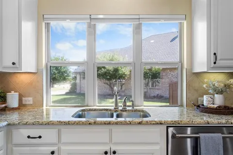 a kitchen with granite countertop a large window and a white counter tops