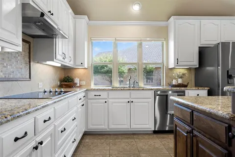 a kitchen with cabinets appliances a sink and a window
