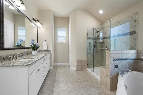 a spacious bathroom with a granite countertop sink mirror and shower