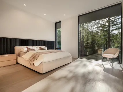 a bedroom with a bed and a large window