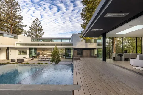 a view of a patio with couches table and chairs and potted plants