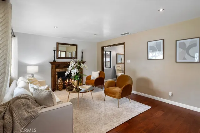 a kitchen with stainless steel appliances granite countertop a stove top oven a refrigerator a sink dishwasher and white cabinets with wooden floor