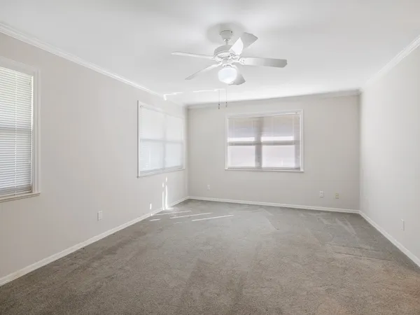 wooden floor in an empty room with a ceiling fan
