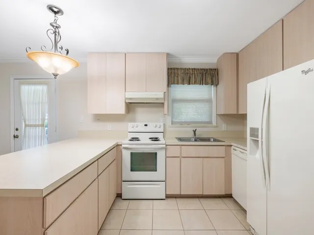 a view of a kitchen with white cabinets and sink