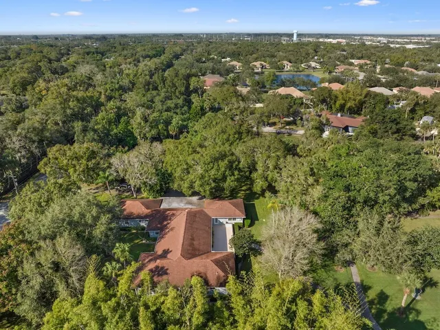 an aerial view of residential houses with outdoor space and trees