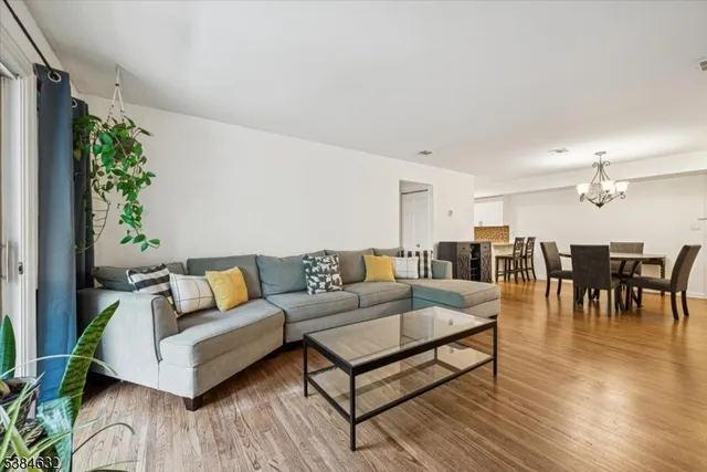 a living room with furniture kitchen view and a potted plant