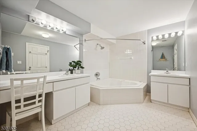 a spacious bathroom with a double vanity sink mirror and bathtub