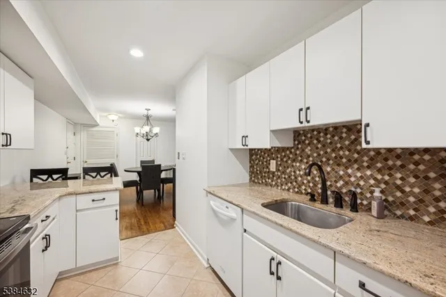 a kitchen with granite countertop a sink a stove and cabinets