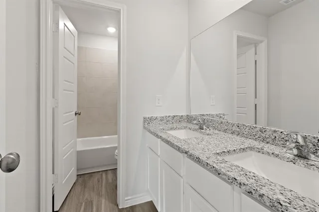 a bathroom with a granite countertop sink and a mirror
