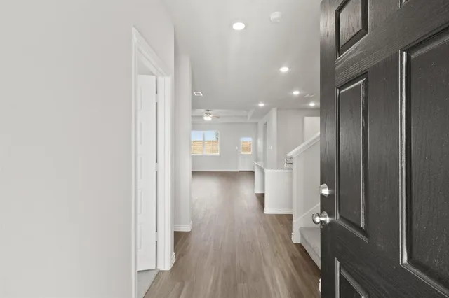 a view of a hallway with wooden floor