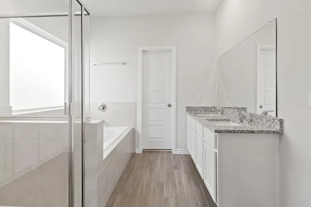 a bathroom with a granite countertop sink a toilet and shower