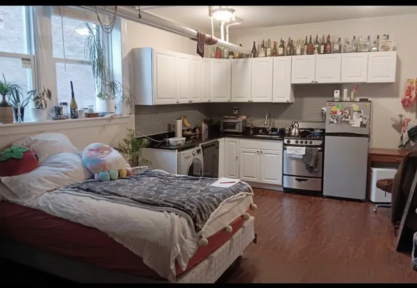 a bedroom with a bed and wooden floor