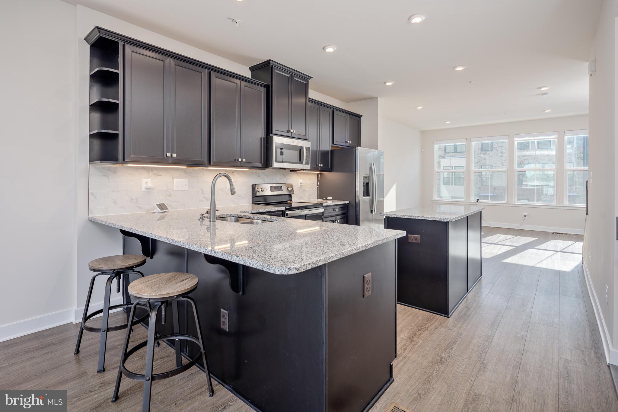 1920 Four Roses Street Baltimore, MD 21222 - Photo 2 of 37 a kitchen with granite countertop a sink a counter space stainless steel appliances and cabinets