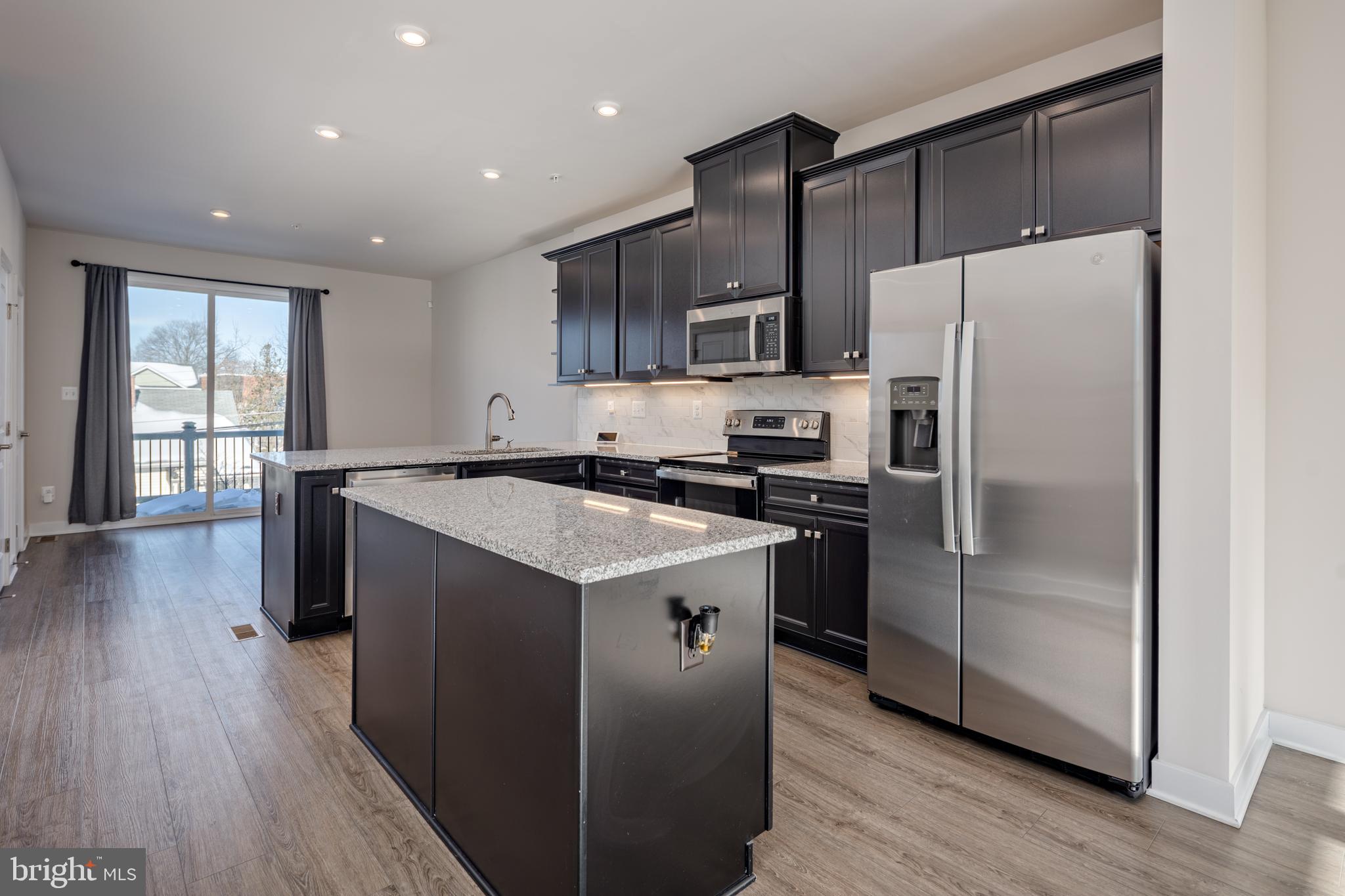 1920 Four Roses Street Baltimore, MD 21222 - Photo 3 of 37 a kitchen with kitchen island a refrigerator wooden floor and a sink