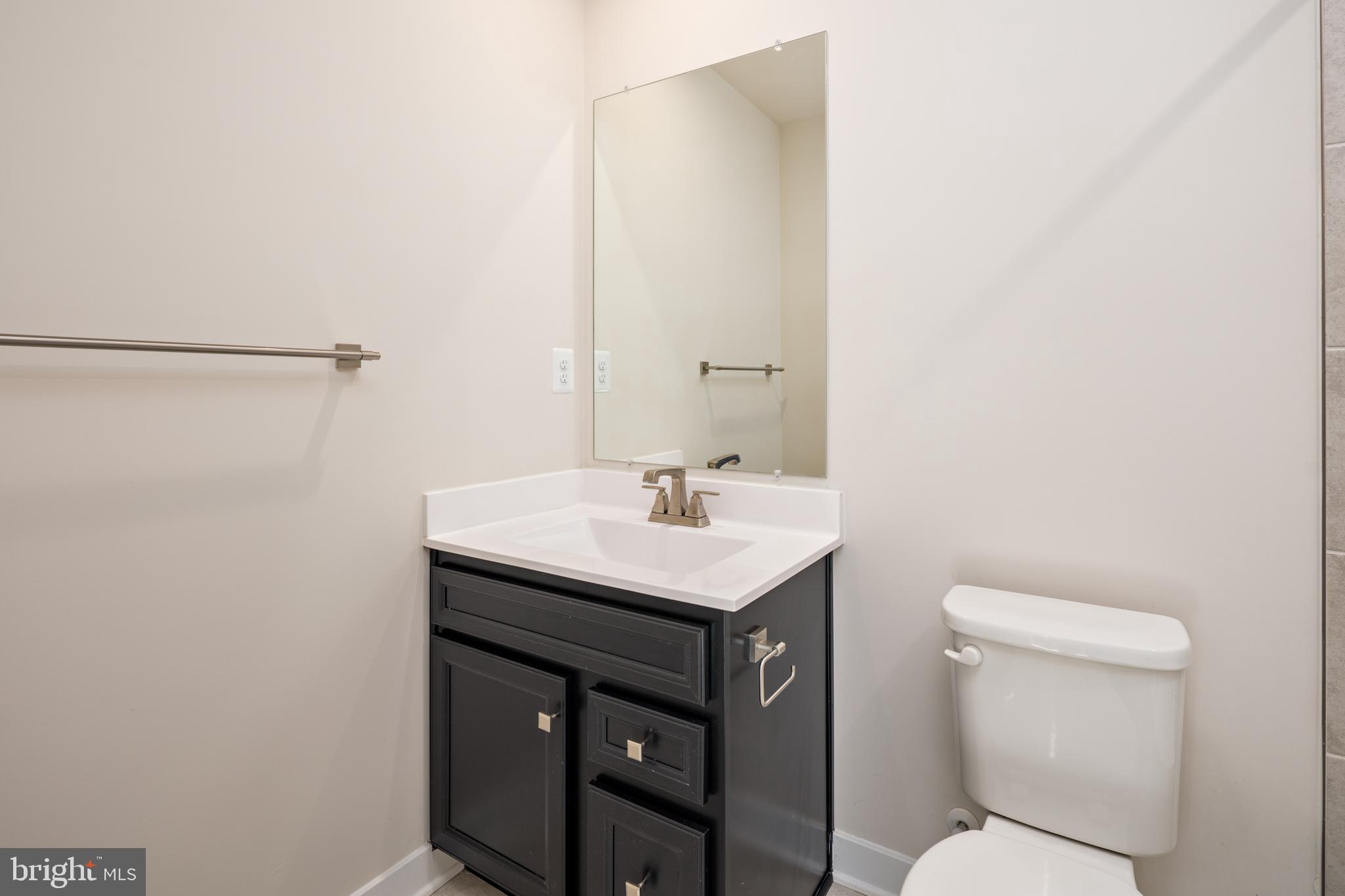 1920 Four Roses Street Baltimore, MD 21222 - Photo 32 of 37 a bathroom with a toilet a sink and mirror