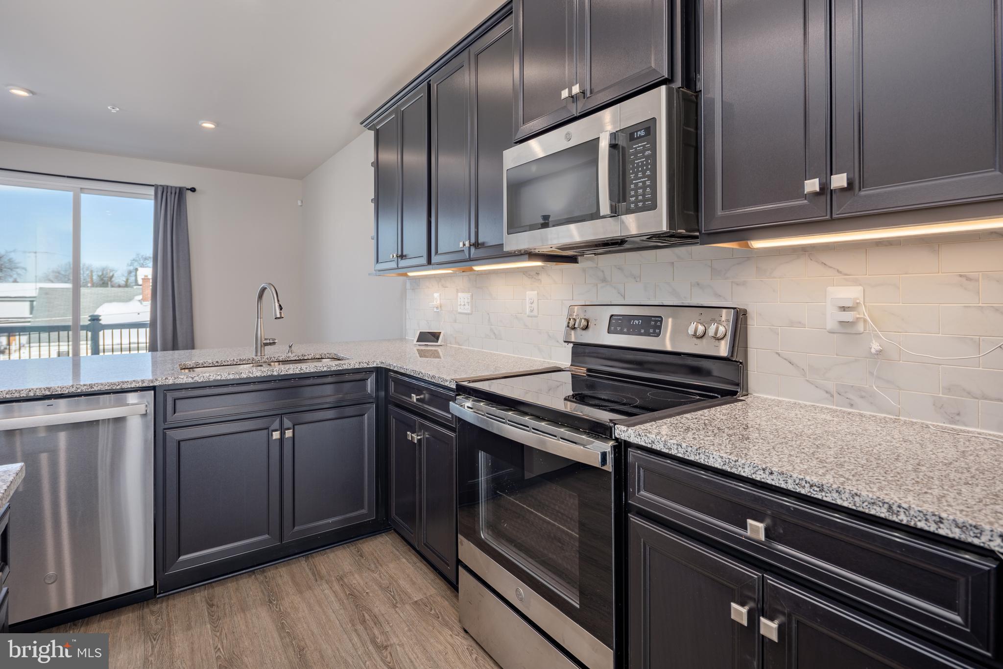1920 Four Roses Street Baltimore, MD 21222 - Photo 10 of 37 a kitchen with stainless steel appliances granite countertop a sink and stove top oven