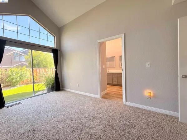 a view of an empty room with a window and a swimming pool