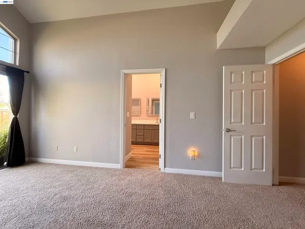 an empty room with windows and closet