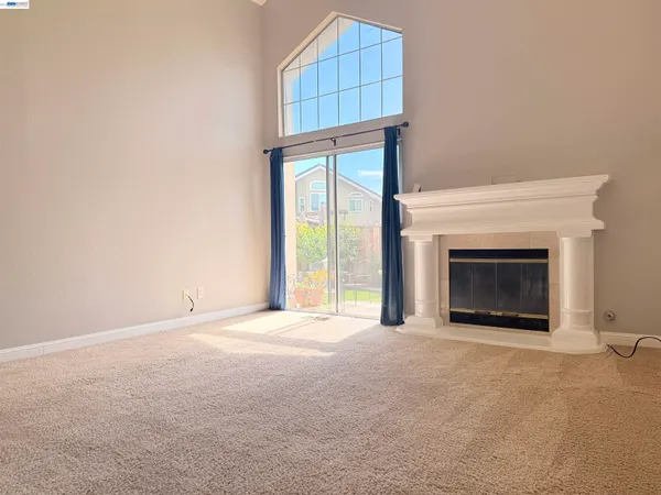 a view of an empty room with a fireplace and a window
