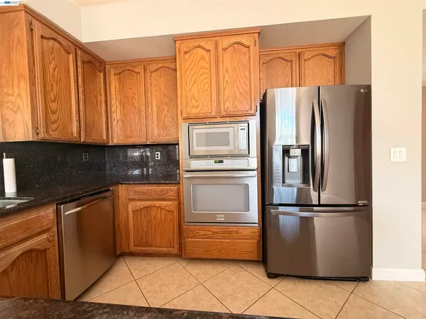 a kitchen with granite countertop a refrigerator and a sink