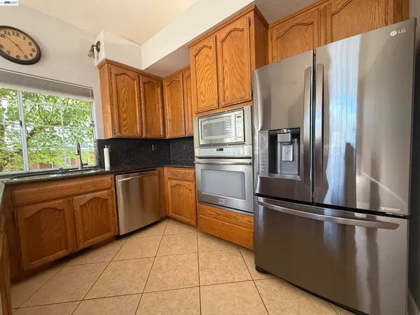 a kitchen with granite countertop a refrigerator and a sink