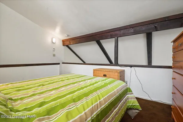 a bedroom with a bed and a lamp on dresser