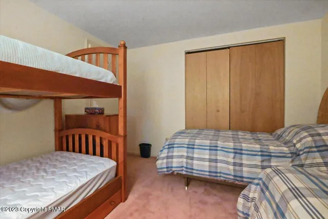 a bedroom with a bed and a lamp on dresser