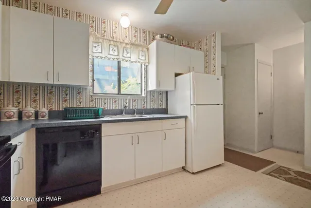 a kitchen with cabinets stainless steel appliances and a window