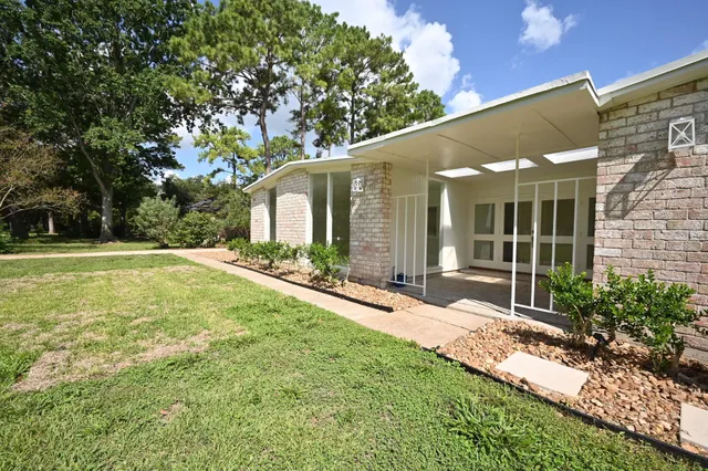 a view of a house with a yard and tree
