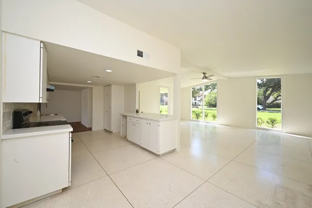 a large kitchen with a stove a refrigerator a sink dishwasher with a dining table and chairs