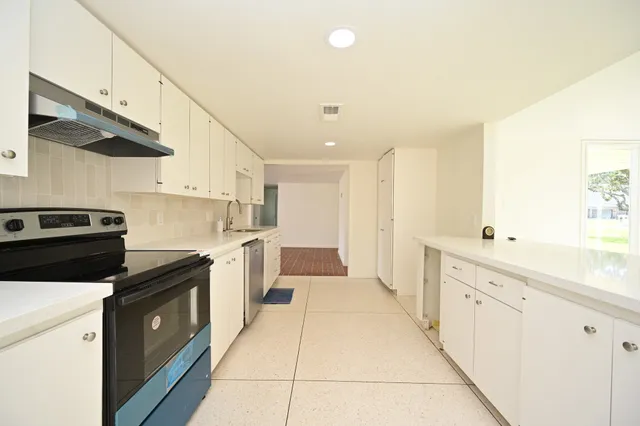 a kitchen with white cabinets and white appliances