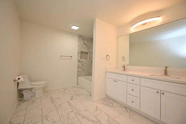 a spacious bathroom with a granite countertop sink mirror and toilet