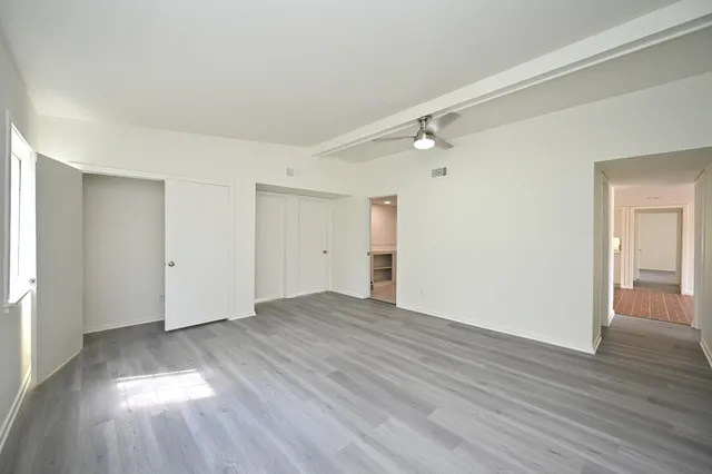 a view of an empty room with wooden floor