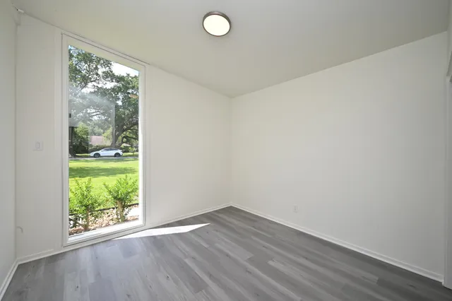 an empty room with wooden floor and a window