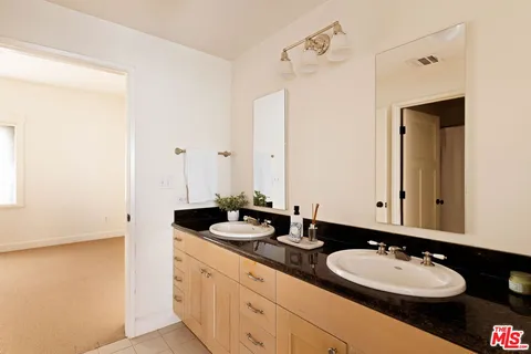 a bathroom with a double vanity sink and a mirror