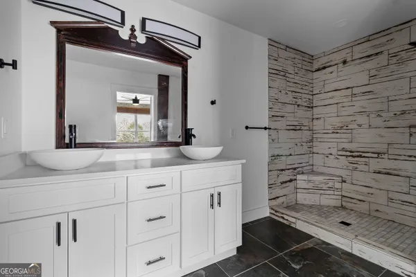 a bathroom with a granite countertop sink a toilet and a mirror