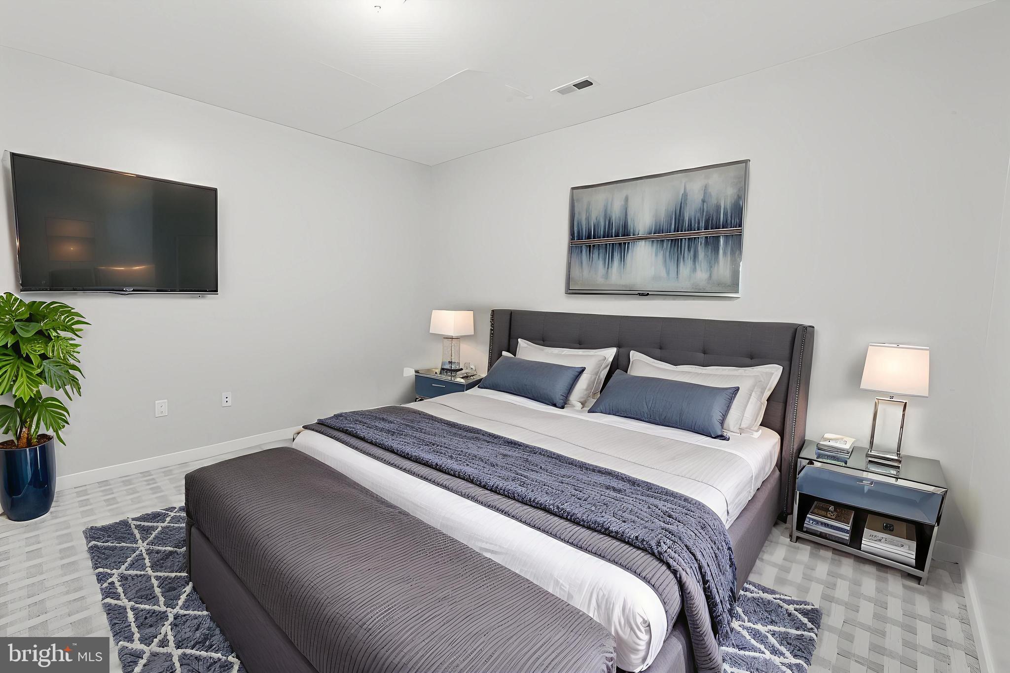 1608 Ridge Avenue, Unit 403 Philadelphia, PA 19130 - Photo 11 of 18 a bedroom with a bed and a flat screen tv