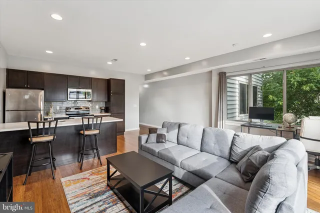 a living room with furniture and a dining table with kitchen view