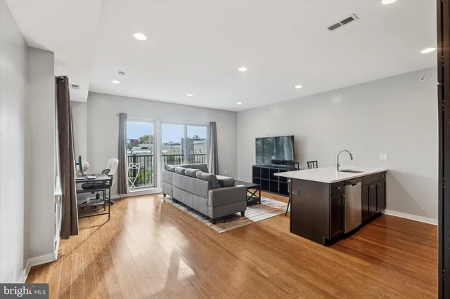 a living room with furniture wooden floor and a flat screen tv