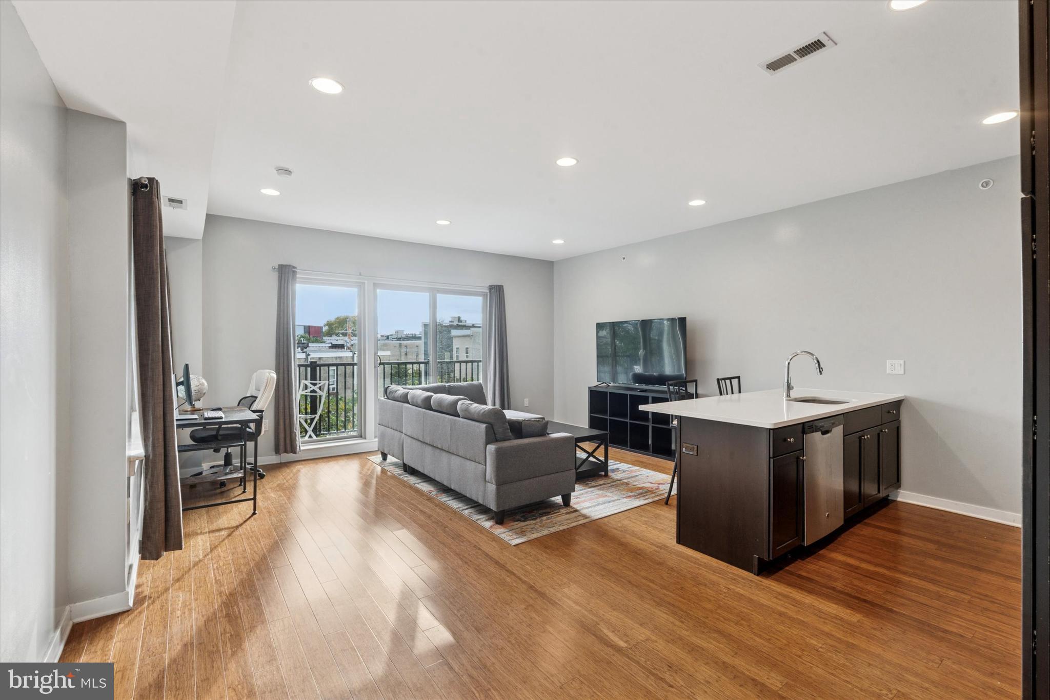 1608 Ridge Avenue, Unit 403 Philadelphia, PA 19130 - Photo 7 of 18 a living room with furniture wooden floor and a flat screen tv